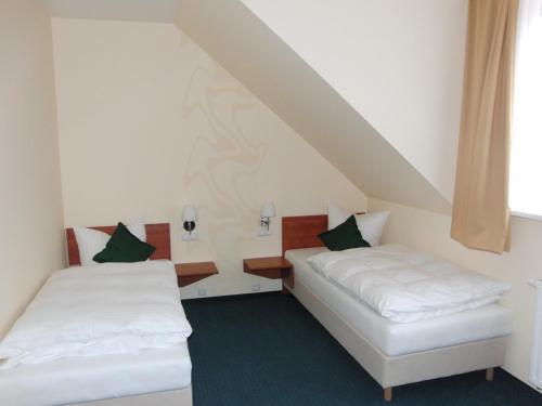 una camera con due letti in mansarda di Hotel Garni Am Kirchplatz a Ilmenau