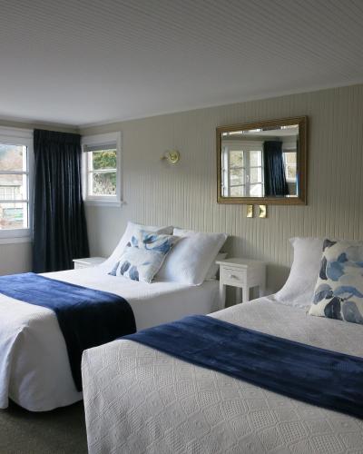 a hotel room with two beds and a mirror at Cheltenham House in Hanmer Springs