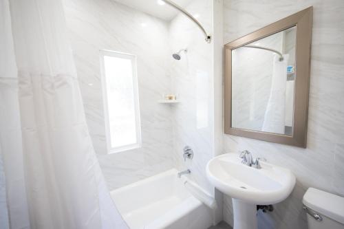 
a bathroom with a sink, toilet and tub at Wilshire Crest Hotel in Los Angeles

