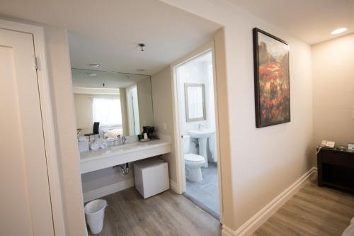 La salle de bains est pourvue d'un lavabo, de toilettes et d'un miroir. dans l'établissement Wilshire Crest Hotel, à Los Angeles