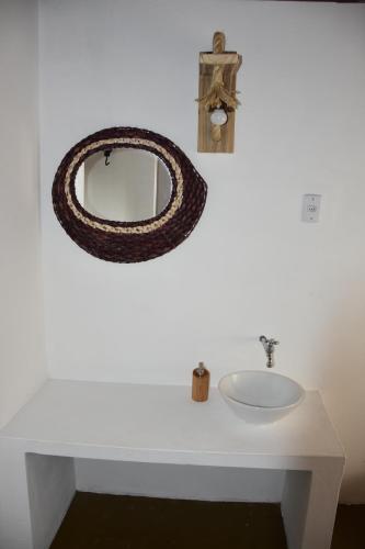 a bathroom with a sink and a mirror on a wall at Pousada Velho Bateau in Atins