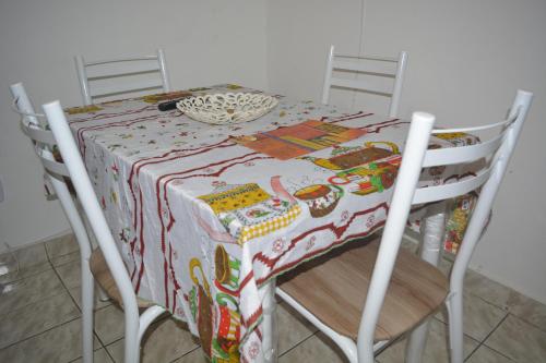 a table with a table cloth on it with two chairs at Apartamento para 7 pessoas próximo a Basílica in Aparecida