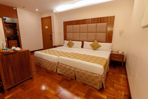 a bedroom with a large bed in a room at City Garden Suites Manila in Manila