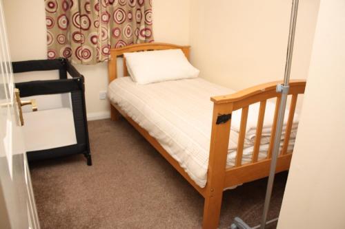 コルチェスターにあるSpacious 3-Bedroom Homeの小さなベッドルーム(ベッド1台、ベビーベッド1台付)
