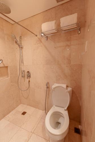 a bathroom with a toilet and a shower at City Garden Suites Manila in Manila