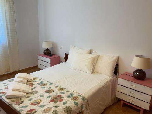 a bedroom with a bed with two night stands and two lamps at Guest House Alfarrobeiras in Albufeira