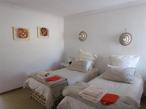 two beds in a hotel room with towels on them at Pumula Guest Farm in Fouriesburg