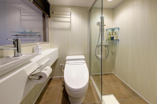 a bathroom with a toilet and a glass shower at Hotel Green Plaza Hakone in Hakone