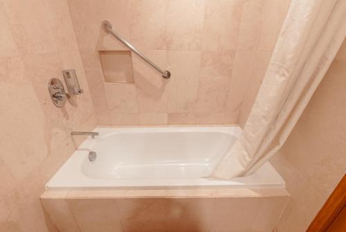 a white tub in a bathroom with a shower at City Garden Suites Manila in Manila