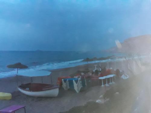 a group of people sitting at a table on the beach at Dar Hachemia in Ras El Ma