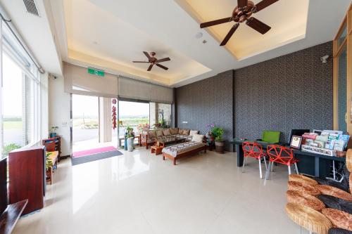 a living room with a couch and a ceiling fan at Green Yard B&B in Hengchun South Gate
