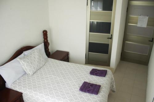 a bedroom with a bed with purple towels on it at Hotel Posada Sernichari in Cuetzalán del Progreso