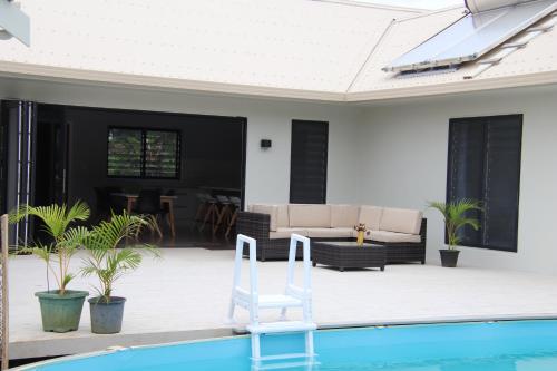 a swimming pool with a white chair next to a house at Matavera Mountain Vista in Matavera