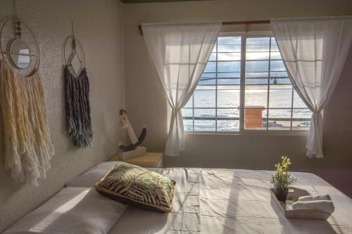 a bedroom with a bed and a large window at 2 BDR - Beachfront Apartment in Concepción