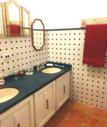 a bathroom with two sinks and a mirror at Villa Vassallo in Ponce
