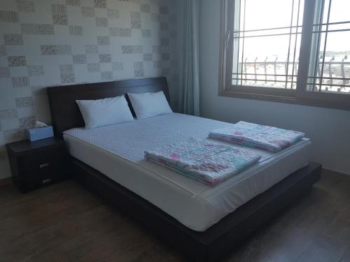 a bed with two pillows on it in a bedroom at Purmir Pension in Seogwipo