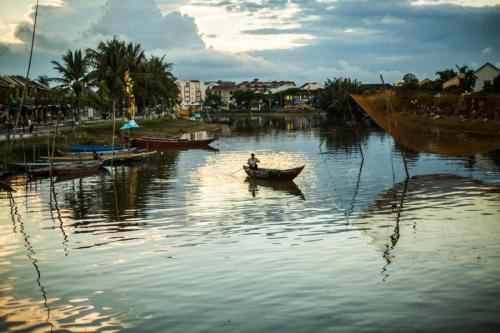 un hombre en un barco en un río en RedRose Villa, en Hoi An