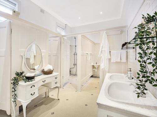 een witte badkamer met een wastafel en een spiegel bij The Robertson Hotel in Robertson