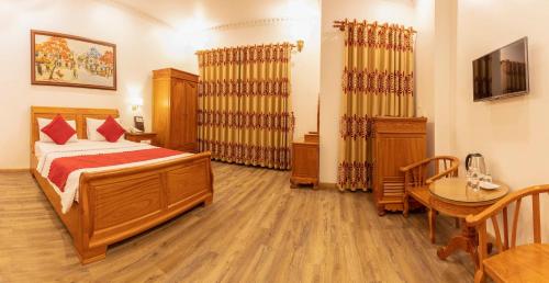 a bedroom with a bed and a table in it at Dragon King 1 Hotel in Da Lat