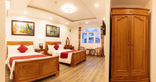 a hotel room with two beds and a window at Dragon King 1 Hotel in Da Lat
