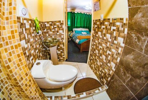 a bathroom with a toilet and a bed in a room at BiosWild in Cusco