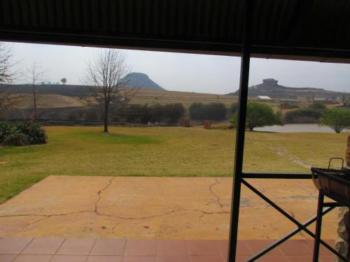 a view from a window of a field with a mountain at Pumula Guest Farm in Fouriesburg