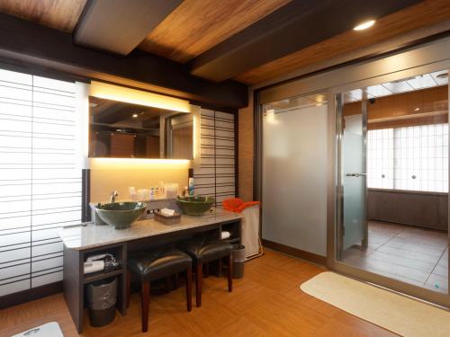 a bathroom with two sinks and a walk in shower at PACIFICO Hotel and Spa in Iwaki