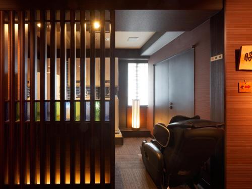 a living room with a leather chair and a window at PACIFICO Hotel and Spa in Iwaki