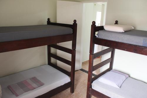 2 Etagenbetten in einem kleinen Zimmer mit Kissen in der Unterkunft Casa mobiliada in São Paulo