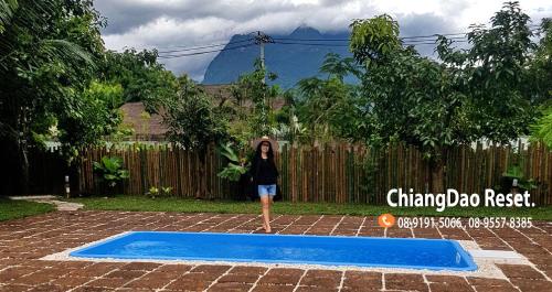 a woman standing in front of a small pool at Chiang Dao Reset in Chiang Dao