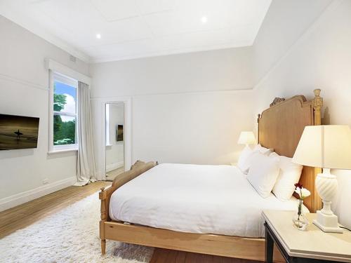 a white bedroom with a large bed and a table at The Robertson Hotel in Robertson