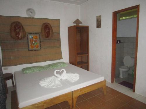 a room with a bed and a bathroom with a toilet at Royal Cliff Resort in Siquijor