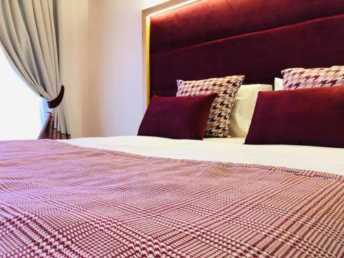 a bed with a red and white comforter and pillows at Garni il Concale in Castel di Sangro