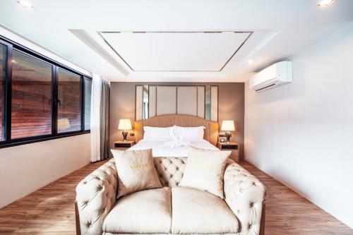 a bedroom with a couch in front of a bed at The Grand Sala Thai in Bangkok