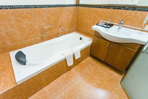a bathroom with a bath tub and a sink at The Park - Silang in Silang