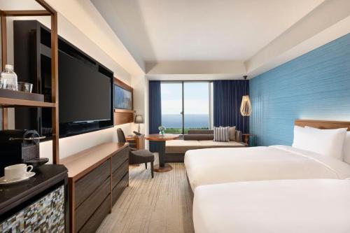 a hotel room with a bed and a flat screen tv at Hyatt Regency Tokyo Bay in Urayasu
