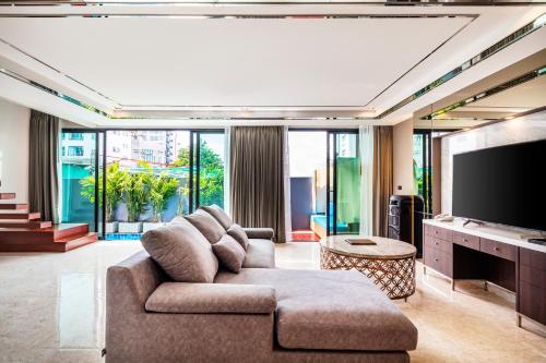 a living room with a couch and a flat screen tv at The Grand Sala Thai in Bangkok