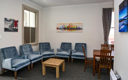 a waiting room with blue chairs and a table at The Prospect of Howick Accommodation in Auckland