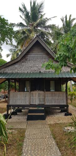 a building with a bench and a palm tree at Sunari Beach Resort 2 in Selayar