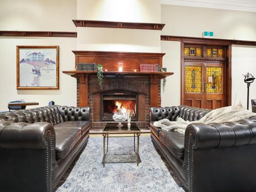 a living room with two leather couches and a fireplace at The Robertson Hotel in Robertson