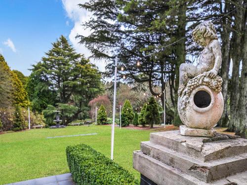 a statue of a woman sitting on a vase in a park at The Robertson Hotel in Robertson