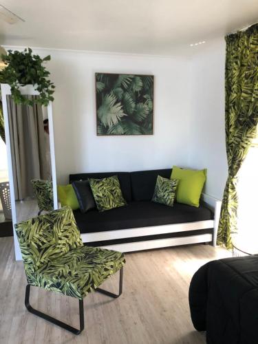 a living room with a black couch and a chair at Maroochy River Bungalows in Diddillibah