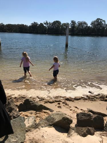 two little girls playing in the water on the beach at Maroochy River Bungalows in Diddillibah