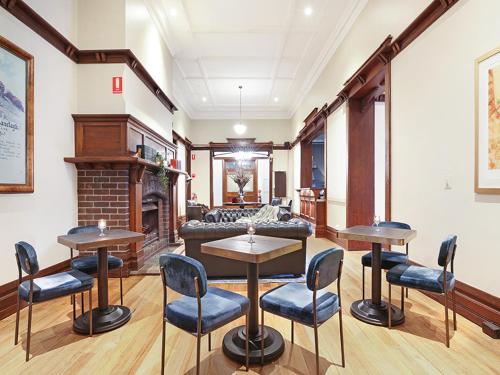 a living room with tables and chairs and a fireplace at The Robertson Hotel in Robertson