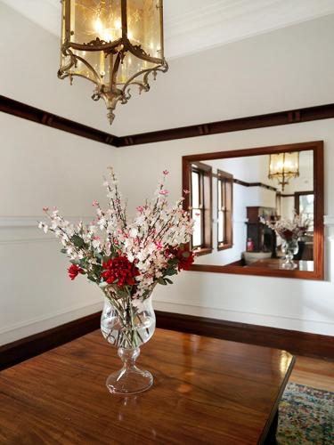 a vase of flowers on a table with a mirror at The Robertson Hotel in Robertson