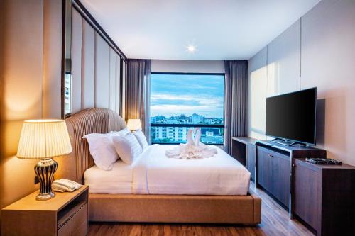 a hotel room with a bed and a television at The Grand Sala Thai in Bangkok