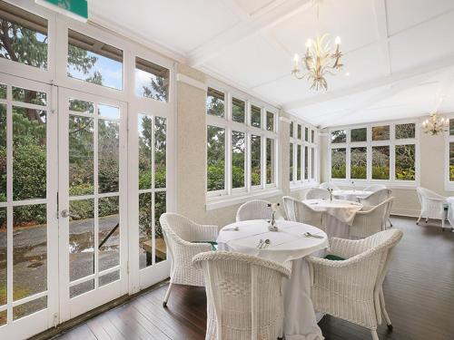 a dining room with tables and chairs and windows at The Robertson Hotel in Robertson