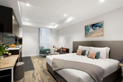 a hotel room with a large bed and a kitchen at Quest North Sydney in Sydney