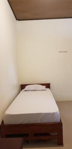 a bed in a room with a white wall at Sunari Beach Resort 2 in Selayar