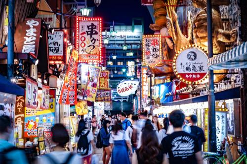a crowd of people walking down a busy city street at night at The Royal Park Canvas - Osaka Kitahama in Osaka